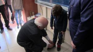 Bakan Avcı öğrencinin ayakkabı bağcıklarını bağladı